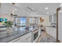 Modern kitchen with white cabinets, granite countertops, and stainless steel appliances at 1211 Gulf Of Mexico Dr # 403, Longboat Key, FL 34228