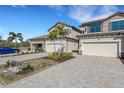 Two-story townhome with attached two-car garage and paver driveway, parked car visible at 17607 Gawthrop Dr # 103, Bradenton, FL 34211