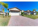 Two-car garage with paver driveway and palm trees at 1810 5Th E St, Palmetto, FL 34221
