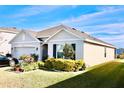 Tan house with a two-car garage and landscaped yard at 2111 Tally Breeze Way, Bradenton, FL 34208