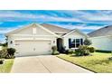 Tan house with a two-car garage and landscaped yard at 2111 Tally Breeze Way, Bradenton, FL 34208