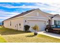Tan house with a two-car garage and landscaped yard at 2111 Tally Breeze Way, Bradenton, FL 34208