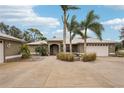 Front view of a single-Gathering house with circular driveway, landscaping, and palm trees at 3011 Ashton Rd, Sarasota, FL 34231