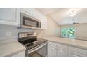 Stainless steel appliances and white cabinetry in kitchen at 4275 Castlebridge Ln # 1312B1, Sarasota, FL 34238