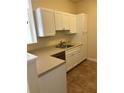 White kitchen cabinets, light countertops, and stainless steel dishwasher at 4802 51St W St # 708, Bradenton, FL 34210