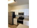 Modern kitchen with white cabinets, stainless steel appliances, and light countertops at 4802 51St W St # 708, Bradenton, FL 34210