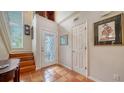Front entry with terracotta tile floors, wooden staircase, and stained glass door at 4892 Peregrine E Pt, Sarasota, FL 34231