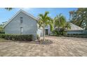 Gray brick house with palm trees and a paver driveway at 4892 Peregrine E Pt, Sarasota, FL 34231