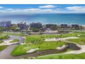 Aerial view of condo complex situated on a golf course near the ocean at 545 Sanctuary Dr # A803, Longboat Key, FL 34228
