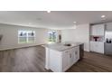 Modern kitchen with white cabinets, island, and stainless steel appliances at 5846 Silver Moonlight Dr, Palmetto, FL 34221