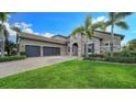Beautiful two-story home with three-car garage and lush landscaping at 6337 Rivo Lakes Blvd, Sarasota, FL 34241