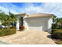 Front view of a one-story house with a white exterior and a large garage at 7160 Rue De Palisades # 4, Sarasota, FL 34238