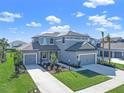 Two-story house with gray exterior, two-car garage, and landscaping at 9511 Tequila Sunrise Dr, Sarasota, FL 34241