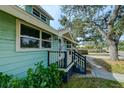 Side view of the house showcasing the porch and landscaping at 1213 5Th W St, Palmetto, FL 34221