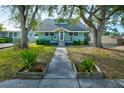 Beautiful light teal house with a grey roof, walkway, and well-manicured lawn at 1213 5Th W St, Palmetto, FL 34221