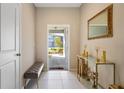 Bright and airy entryway with decorative console table and bench at 14350 Easy Goer St, Ruskin, FL 33573