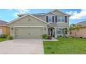 Two-story house with a green facade, landscaping, and a two-car garage at 15812 High Bell Pl, Bradenton, FL 34212