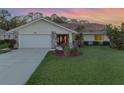 Single-story home with attached garage, landscaping, and a terracotta roof at 1726 Killdeer Cir, Venice, FL 34293