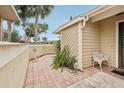 Small condo patio with tile flooring, potted plants, and a white metal chair at 3001 Seawind Cir # 10C, Venice, FL 34293