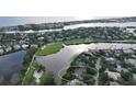 An aerial view showcasing a luxurious waterfront home in a golf course community at 3310 Sabal Cove Ln, Longboat Key, FL 34228