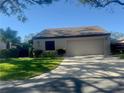 Front view of a villa with an attached garage and a well-maintained lawn at 3725 Glen Oaks Manor Dr, Sarasota, FL 34232