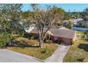 House nestled amongst lush greenery and a quiet street in a residential area at 3807 64Th St W, Bradenton, FL 34209