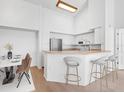 Modern kitchen with white cabinets, stainless steel appliances, and a breakfast bar at 4152 Central Sarasota Pkwy # 727, Sarasota, FL 34238