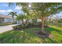 Single-story home with attractive landscaping, a spacious driveway, and a water view at 5213 Asher Ct, Sarasota, FL 34232