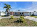 Tan single story home with coral colored door and palm trees at 524 Palm Ave, Ellenton, FL 34222