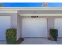 Attached garage with white door and landscaping at 5697 Sheffield Greene Cir # 51, Sarasota, FL 34235