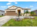 One-story house with brown garage door, gray door, and landscaped yard at 7308 Tangle Bend Dr, Gibsonton, FL 33534