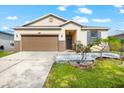 One-story house with brown garage door, gray door, and landscaped yard at 7308 Tangle Bend Dr, Gibsonton, FL 33534