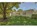 Side view of the house showing additional landscaping and a tree-lined street at 7331 Westmoreland Dr, Sarasota, FL 34243