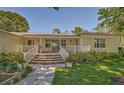 Inviting front porch with brick flooring, white railing, and a wooden bench at 7331 Westmoreland Dr, Sarasota, FL 34243
