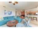 Spacious living room with teal sectional sofa and adjacent kitchen at 8105 Grand Estuary Trl # 307, Bradenton, FL 34212