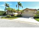 Tan two-car garage with decorative accents and landscaping at 3416 W Chelmsford Ct # 2, Sarasota, FL 34235