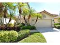 Tan stucco home with tile roof, palm trees, and manicured landscaping at 3416 W Chelmsford Ct # 2, Sarasota, FL 34235