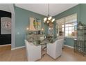 Elegant dining room with a glass table and chandelier at 348 165Th Ne Ct, Bradenton, FL 34212