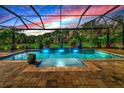 Relaxing screened pool and spa with water features at sunset at 348 165Th Ne Ct, Bradenton, FL 34212