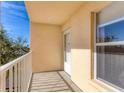 Private balcony with white railings, door and window, overlooking trees at 4110 Ironwood Cir # 301, Bradenton, FL 34209