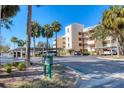 Three-story condo building with palm trees, parking and a sign; daytime photo at 4110 Ironwood Cir # 301, Bradenton, FL 34209