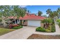 Two-story home with tile roof, landscaped yard, and driveway at 5376 Shadow Lawn Dr, Sarasota, FL 34242