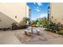 Courtyard with brick pavement, seating, and tropical plants at 618 Bird Bay S Dr # 201, Venice, FL 34285