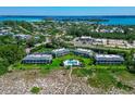 Aerial view showcasing a beachfront community with a pool at 6925 Gulf Of Mexico Dr # 24, Longboat Key, FL 34228
