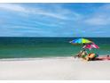Relaxing beach scene with couple under beach umbrella at 6925 Gulf Of Mexico Dr # 24, Longboat Key, FL 34228