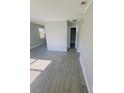 Bright living room with grey wood-look floors and hallway at 739 52Nd N Ave, St Petersburg, FL 33703