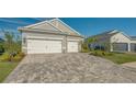 Gray house with white garage doors and a paved driveway at 10269 Canaveral Cir, Sarasota, FL 34241