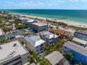 Aerial view of a beach community showcasing a modern two-story house near the ocean at 106 9Th S St, Bradenton Beach, FL 34217