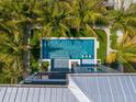 Elevated view of a rectangular swimming pool with a spa, surrounded by lush landscaping at 106 9Th S St, Bradenton Beach, FL 34217