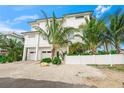 White three-story home with attached two-car garage at 116 8Th Street S, Bradenton Beach, FL 34217